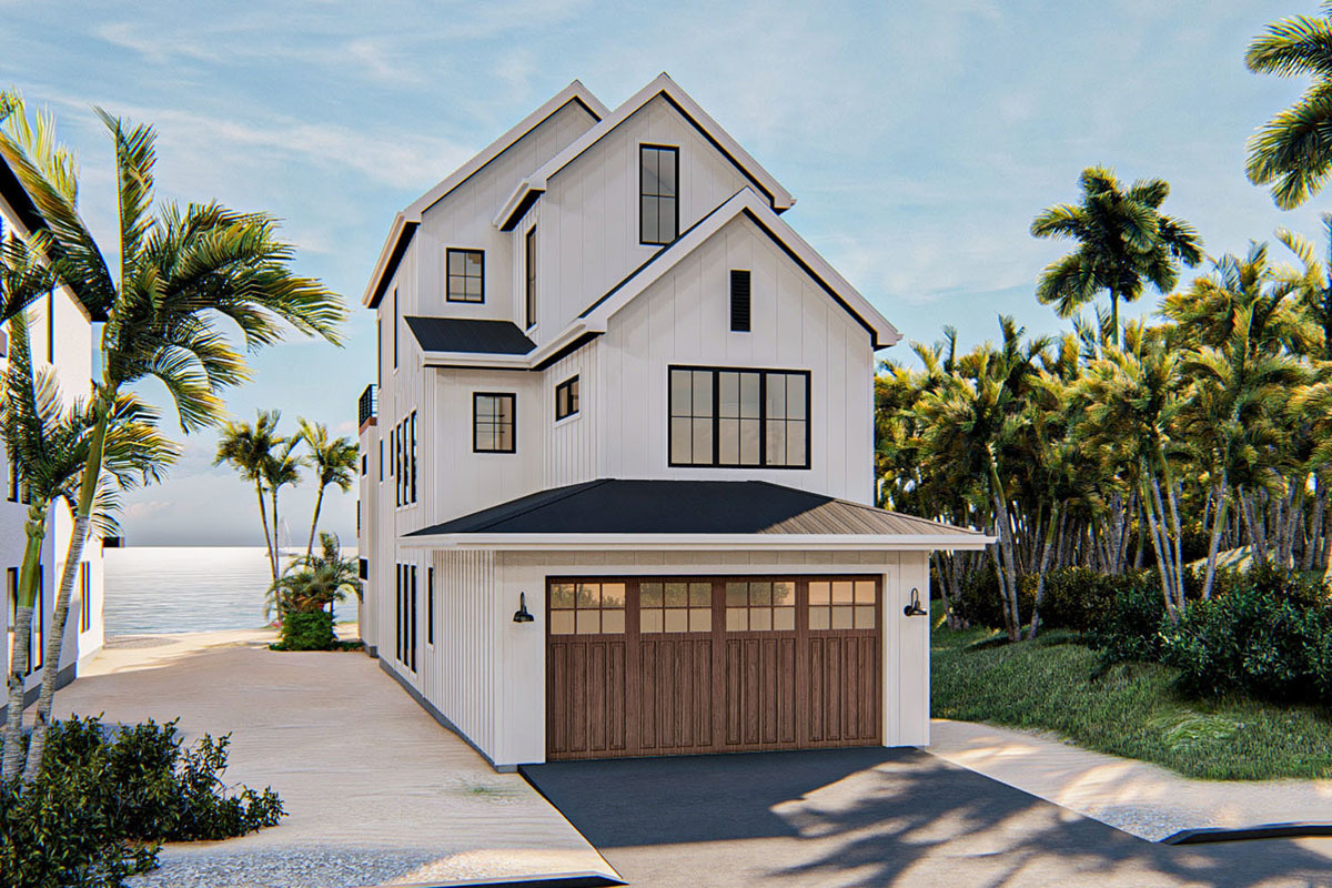 Modern beach house exterior featuring a white facade, black roof, and wooden garage doors, surrounded by palm trees and a sandy pathway leading to the ocean.