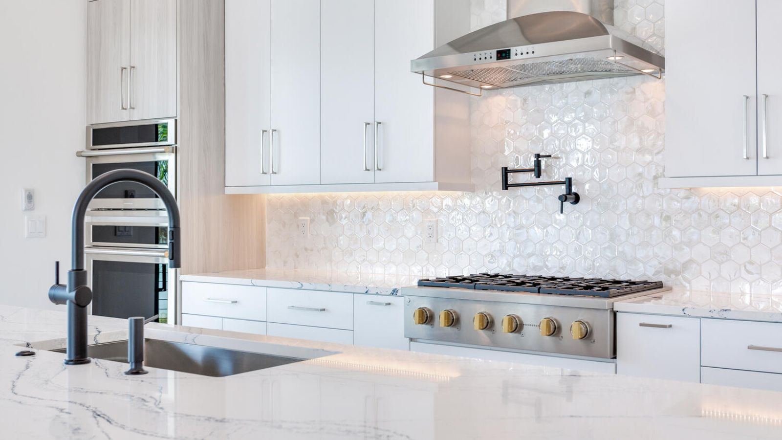 A kitchen with marble counter tops and stainless steel appliances