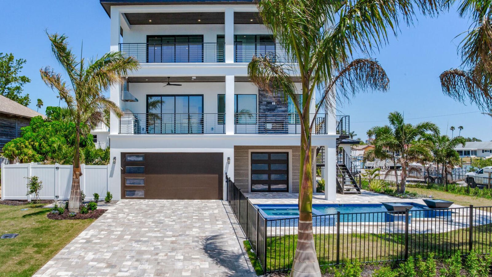 a modern home with a pool and palm trees