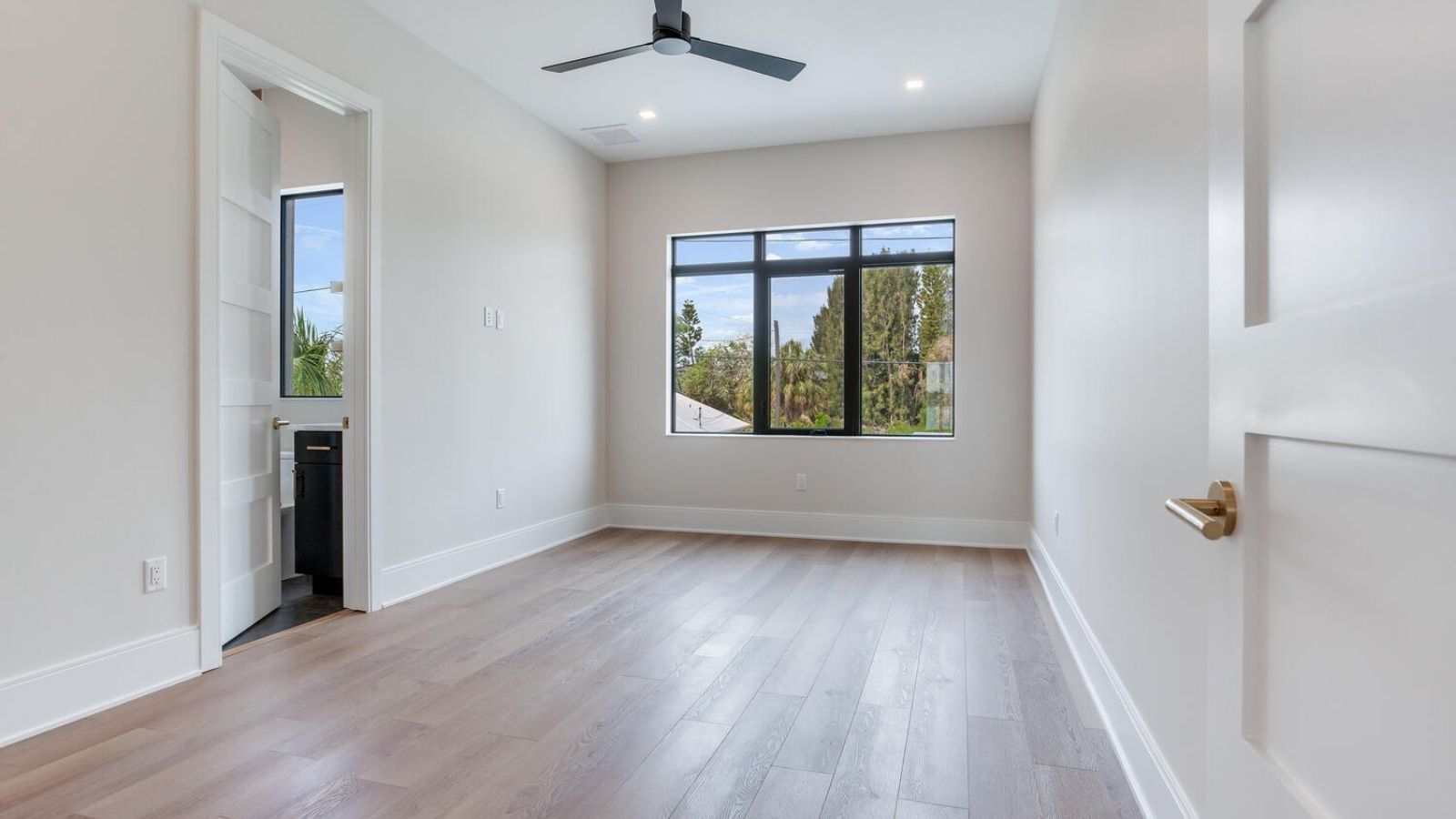 an empty room with hardwood floors and a ceiling fan