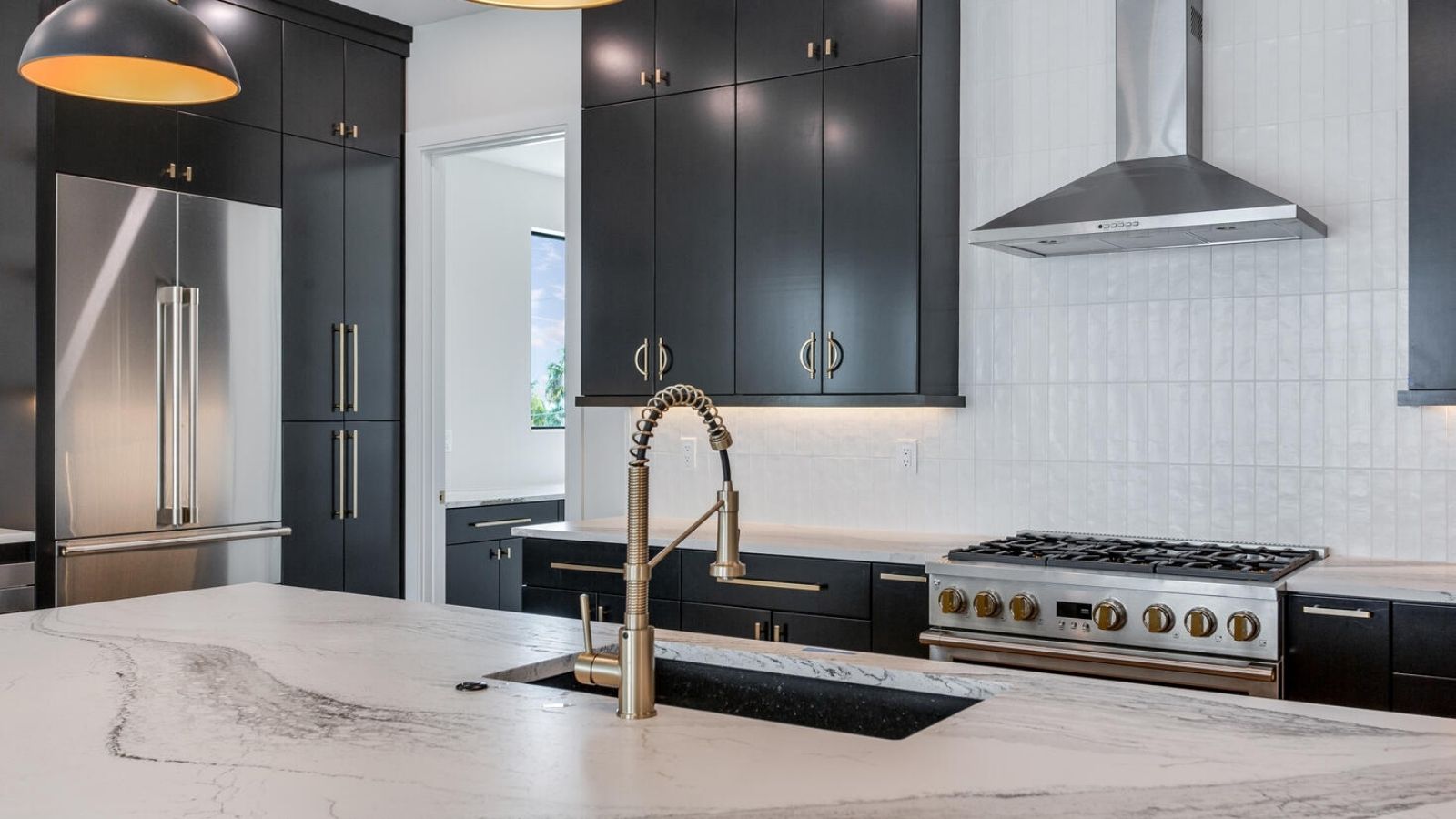 a modern kitchen with black cabinets and marble counter tops
