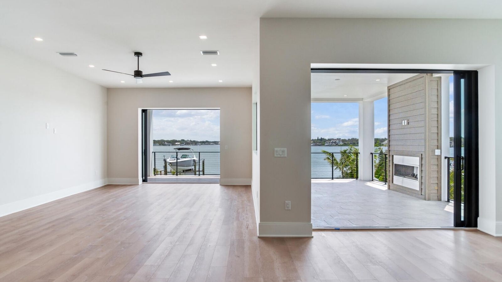 an empty living room with hardwood floors and a view of the water