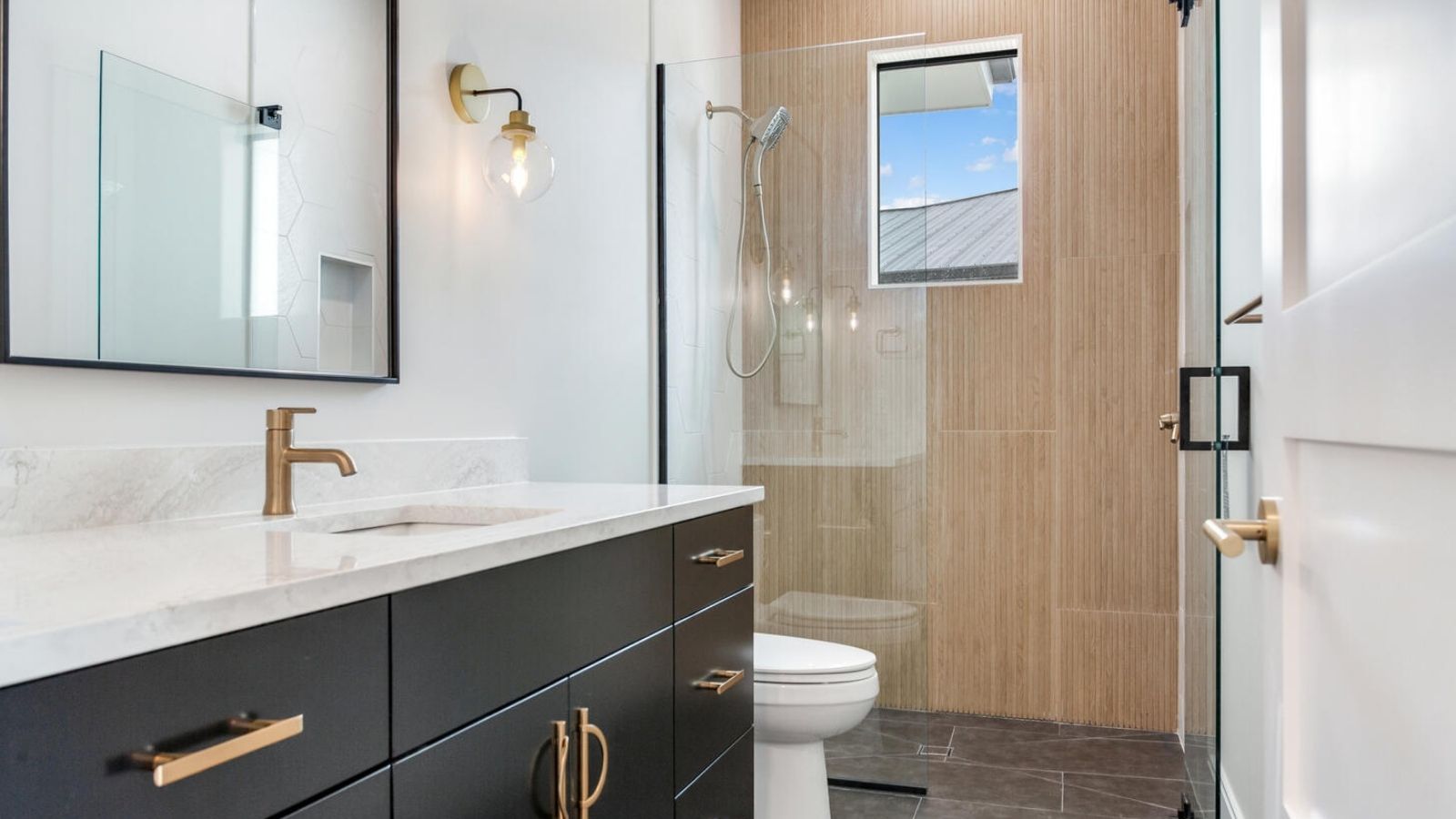 a modern bathroom with black cabinets and white counter tops