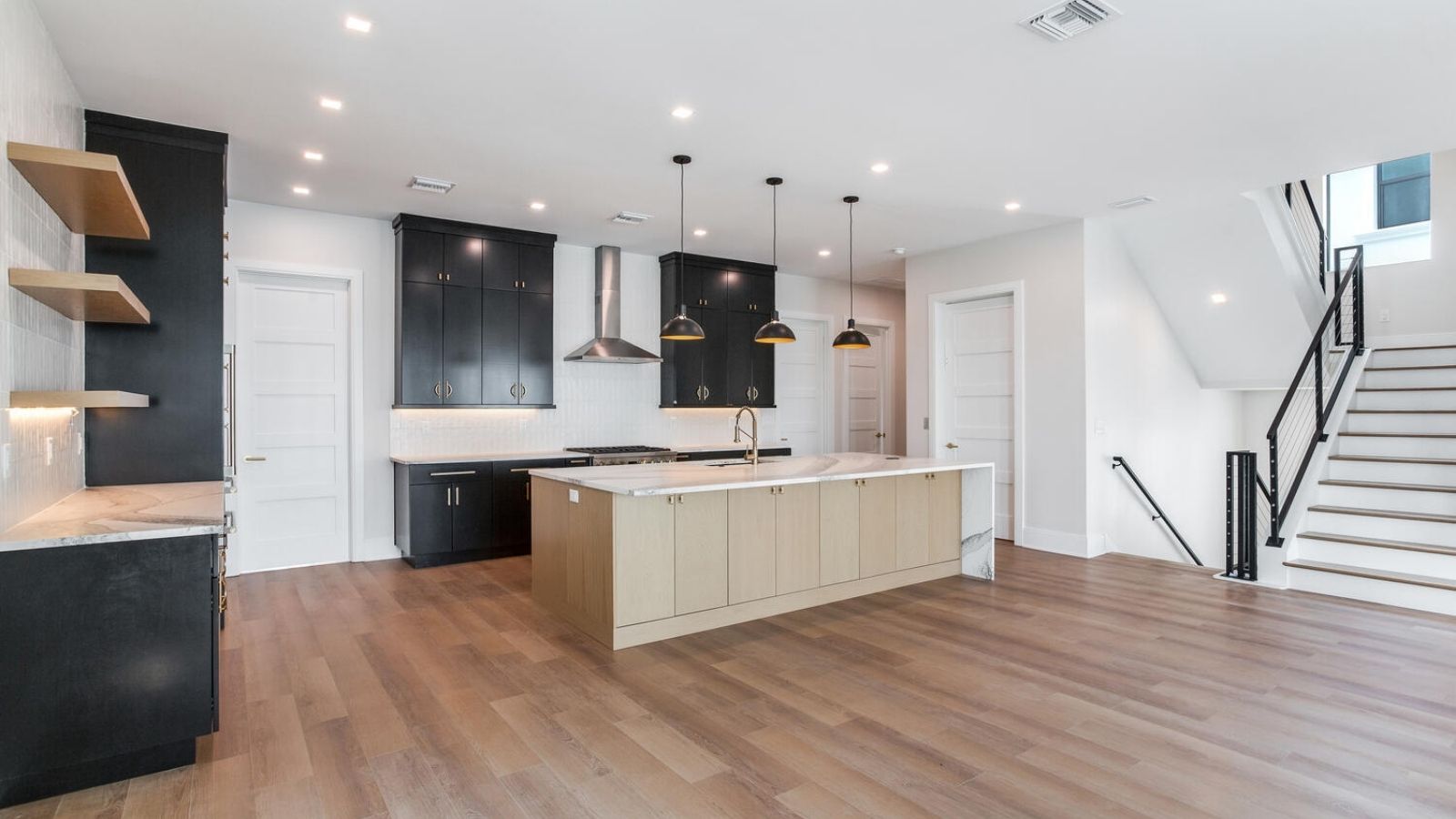 a kitchen with hardwood floors and black cabinets