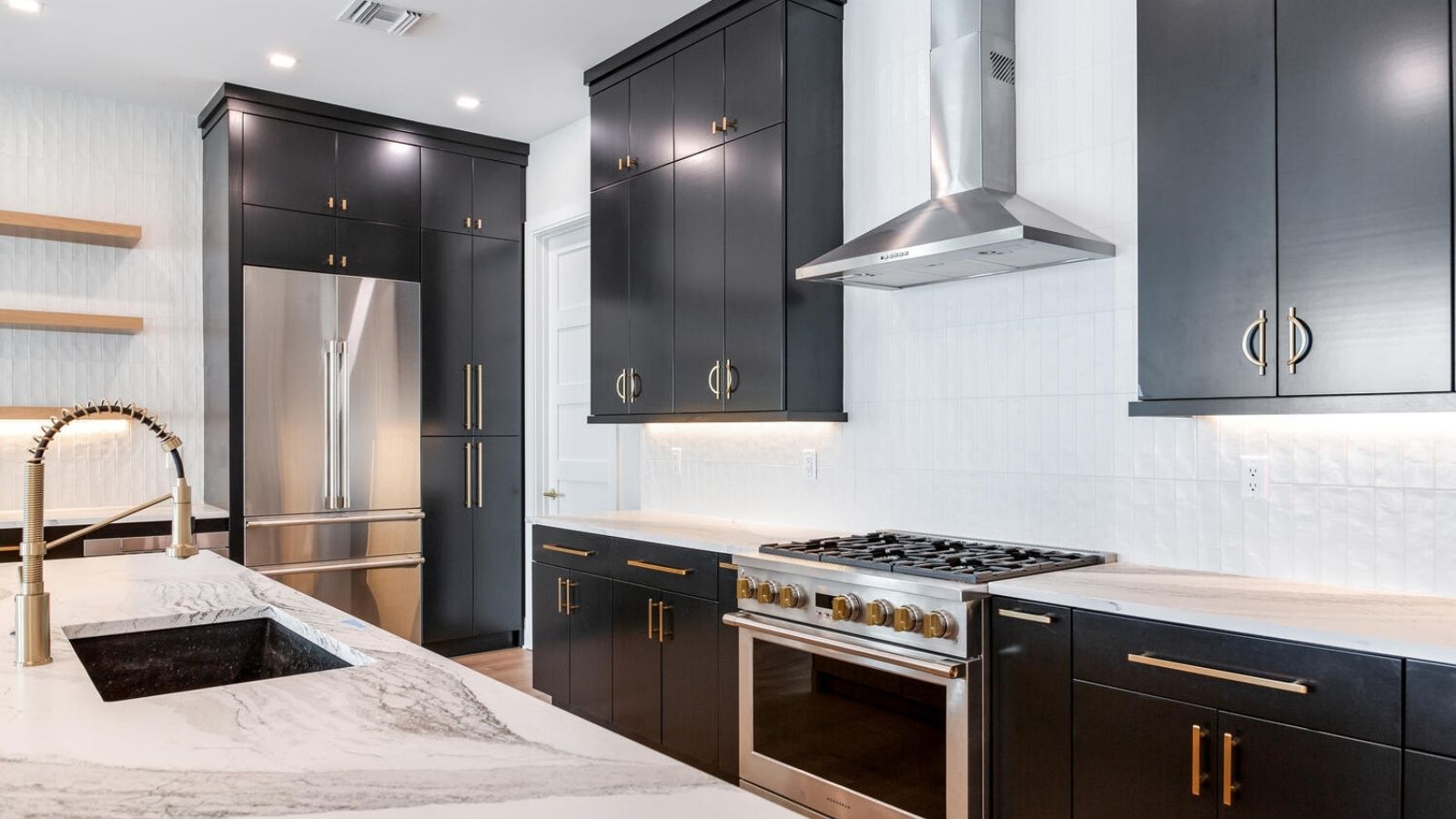 a modern kitchen with black cabinets and marble counter tops