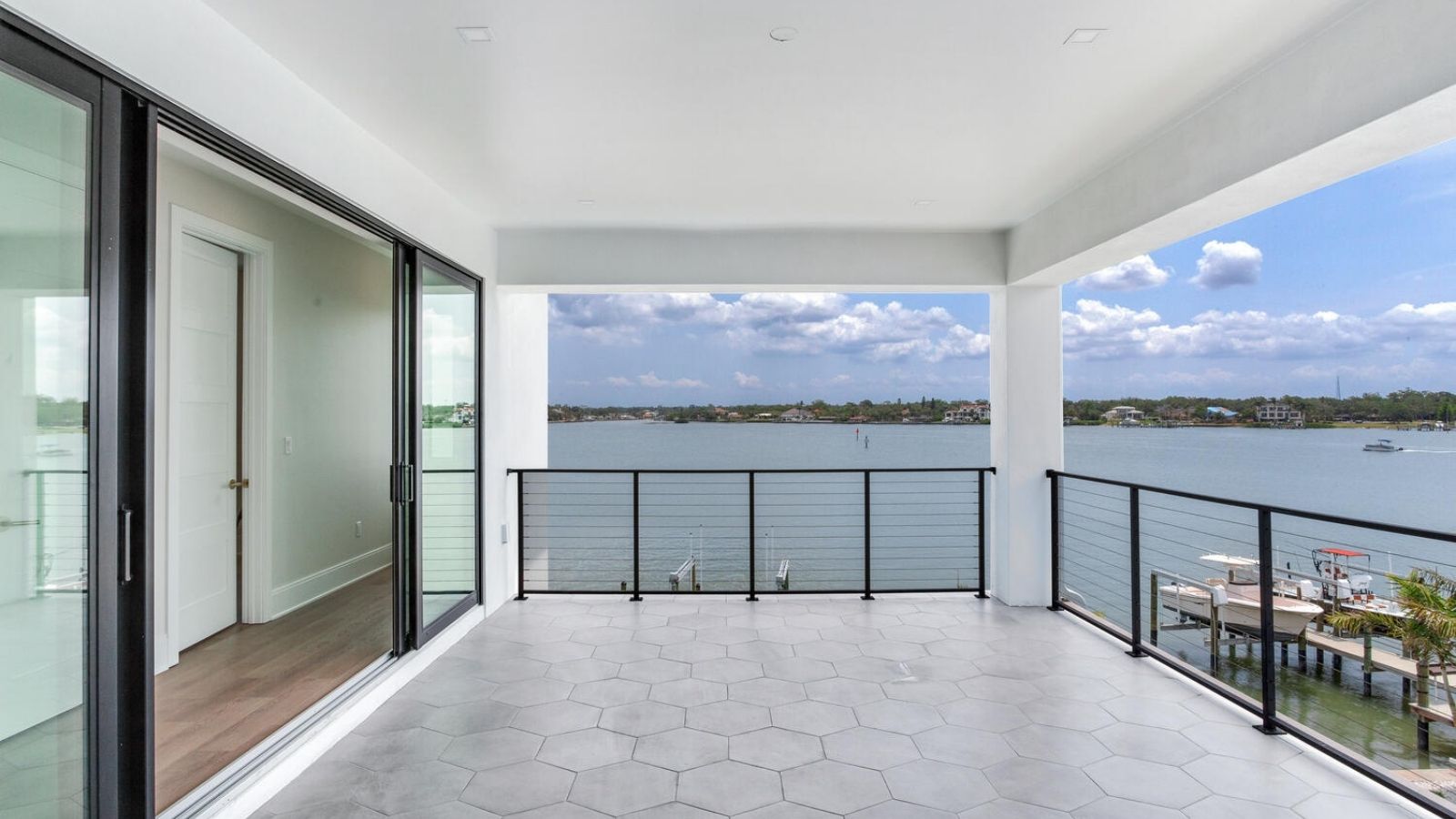a balcony overlooking the water with sliding glass doors