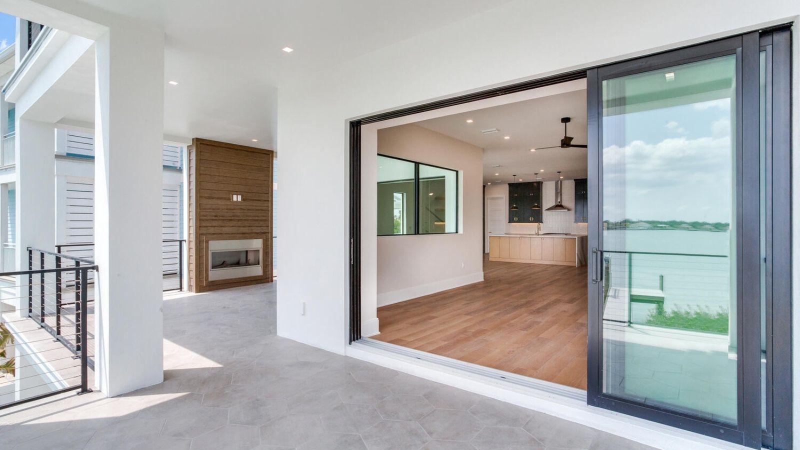 an open patio with sliding glass doors and a view of the water