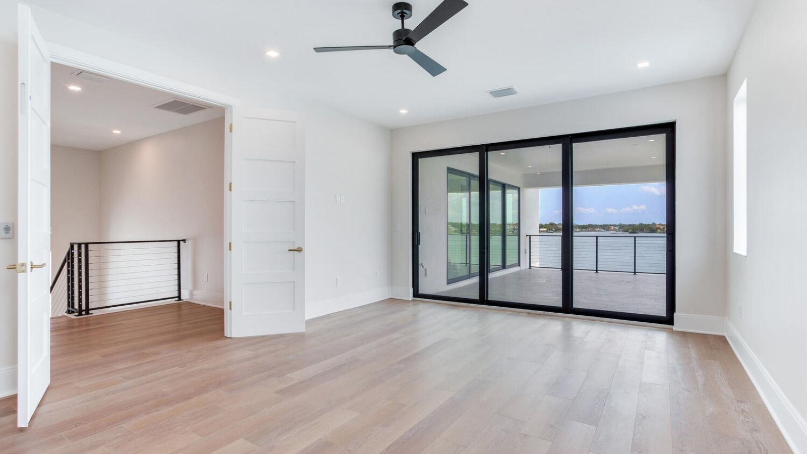 an empty room with hardwood floors and sliding glass doors