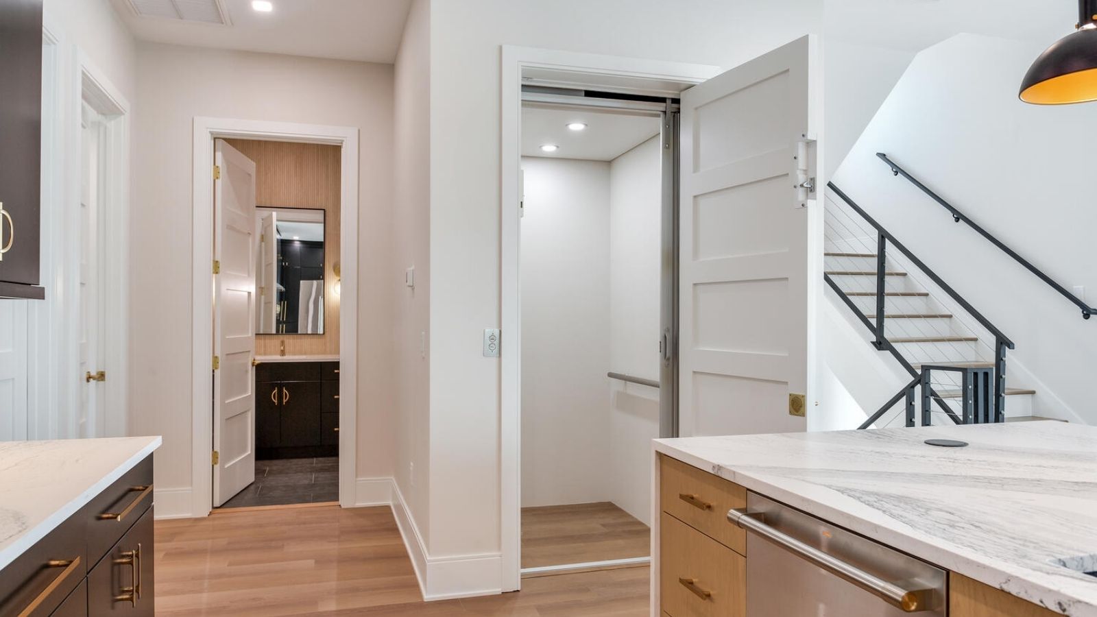 a kitchen with white cabinets and wooden floors