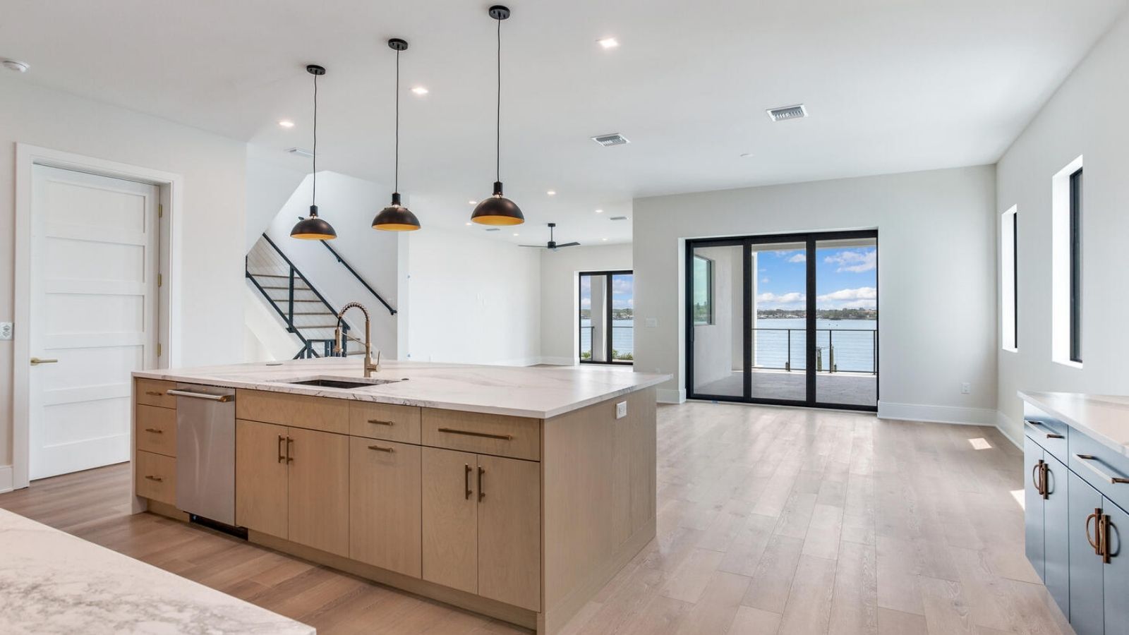 an open kitchen with hardwood floors and stainless steel appliances