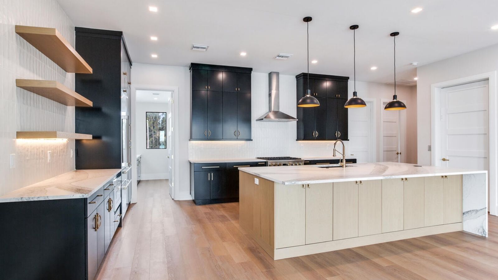 a kitchen with wood floors and black cabinets