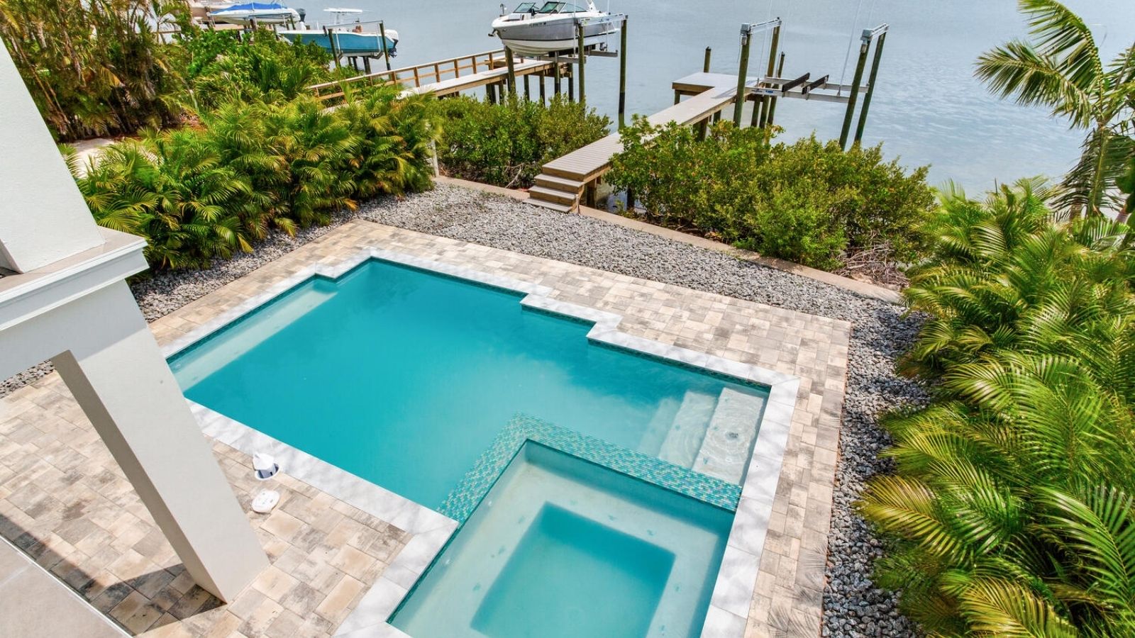 a swimming pool surrounded by palm trees and with an ocean view