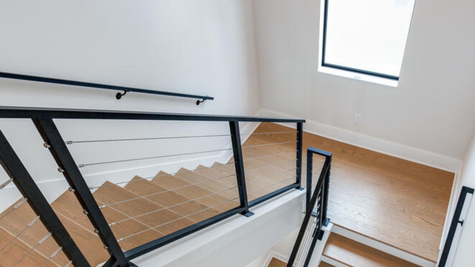 a stairway with white walls and black railings