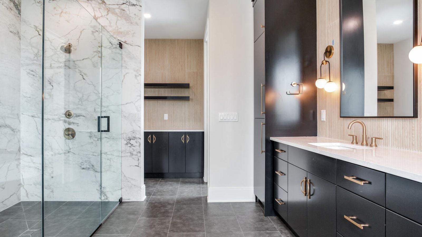 a modern bathroom with black cabinets and marble counter tops