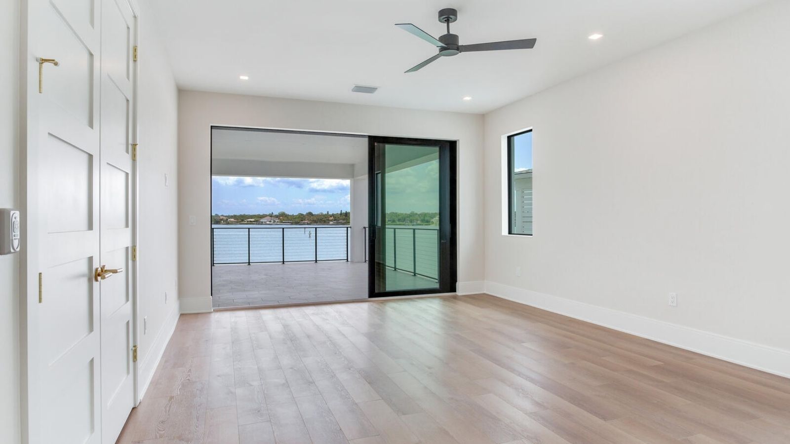 an empty room with hardwood floors and sliding glass doors