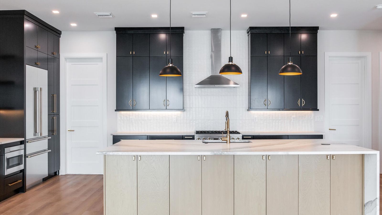 a modern kitchen with black cabinets and white counter tops