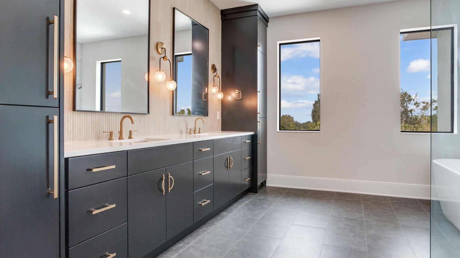 a large bathroom with black cabinets and a large tub