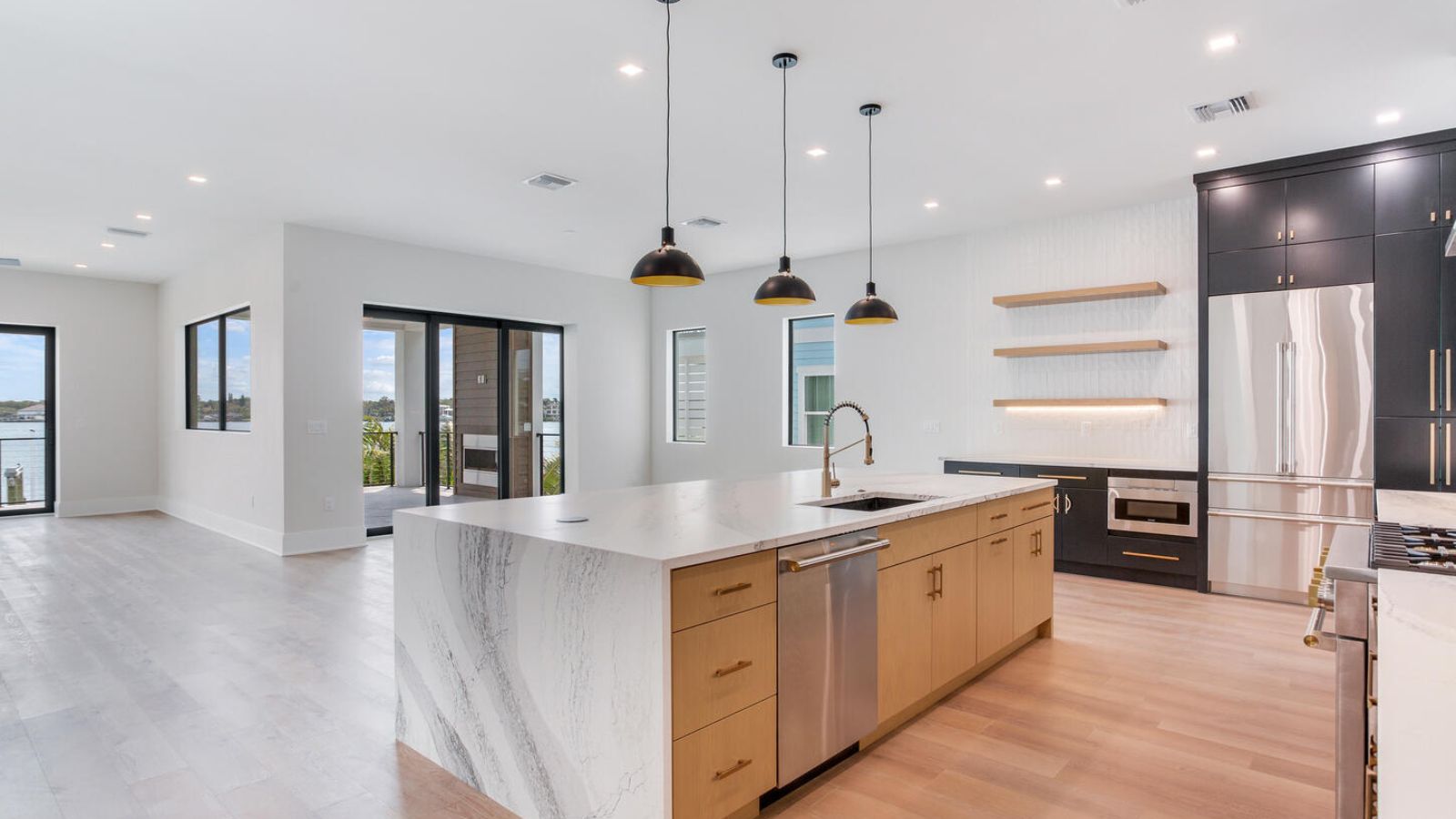an open kitchen with hardwood floors and stainless steel appliances