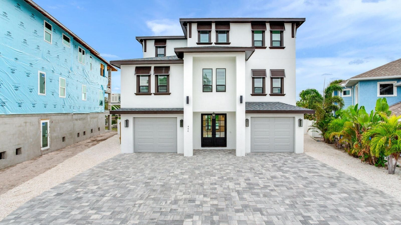 three-story custom home with dual garages and coastal architecture built by Aventis Homes in Florida