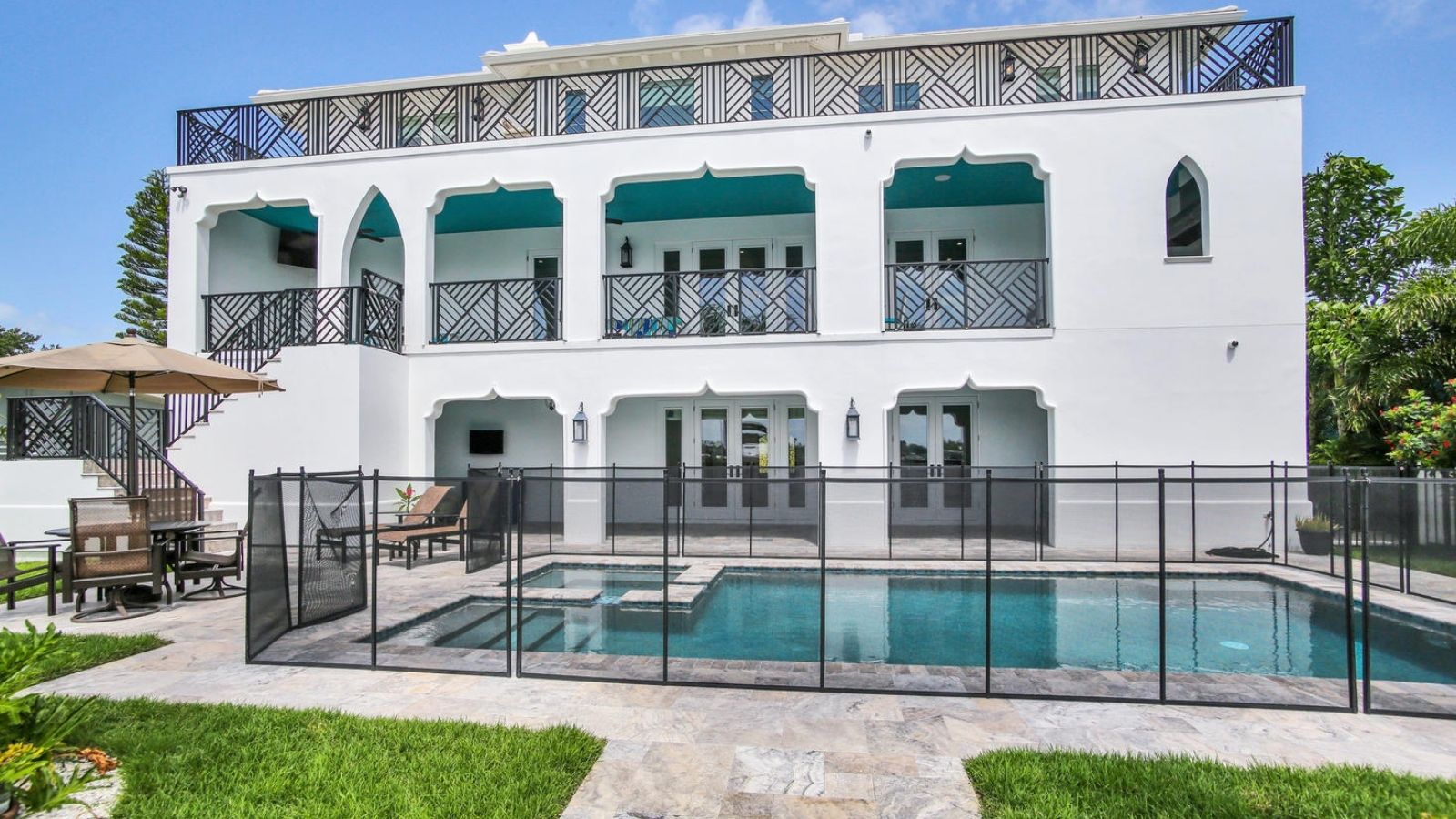 a large white house with a pool and patio