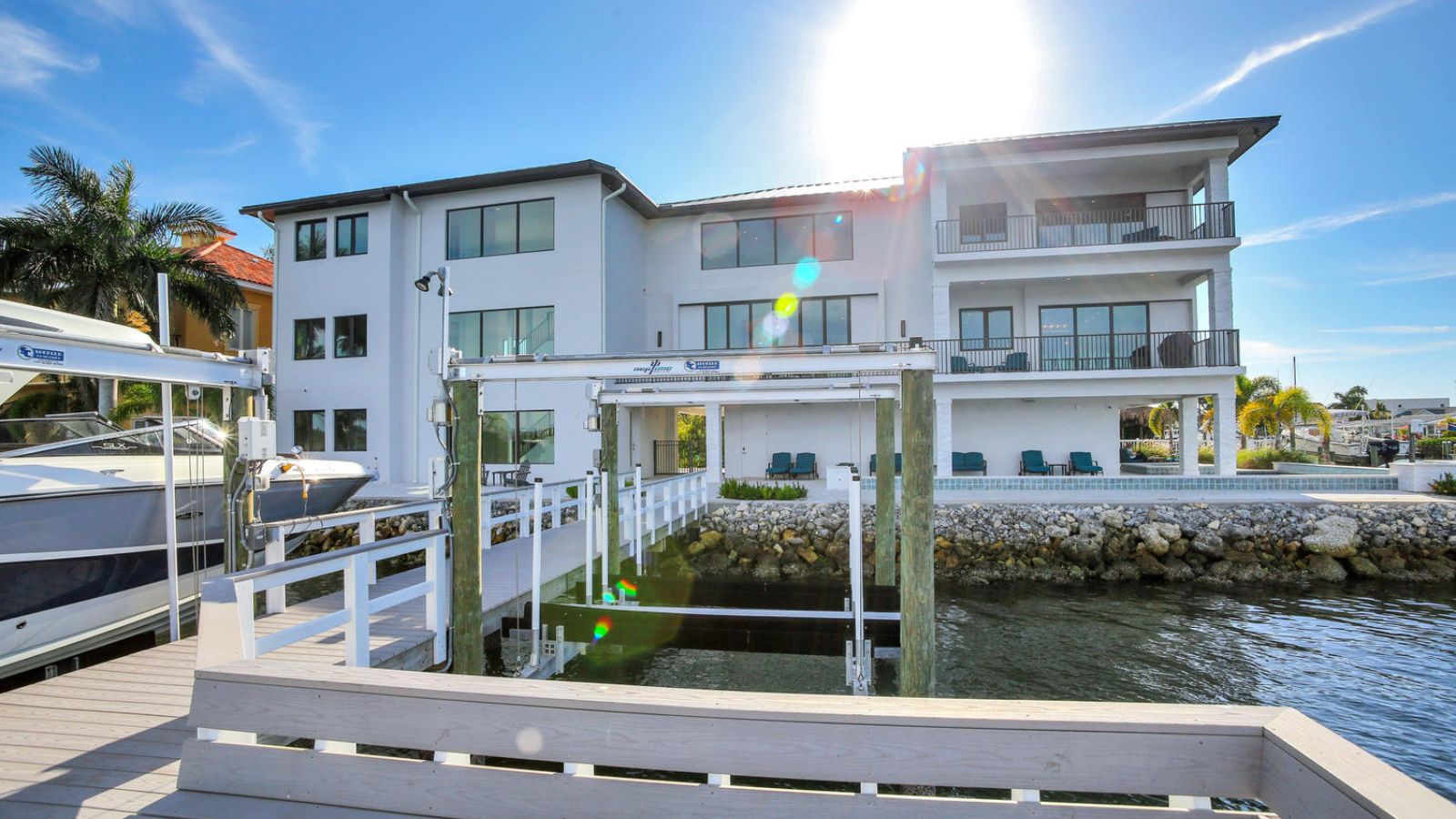 Waterfront exterior view with modern coastal buildings and private dock.