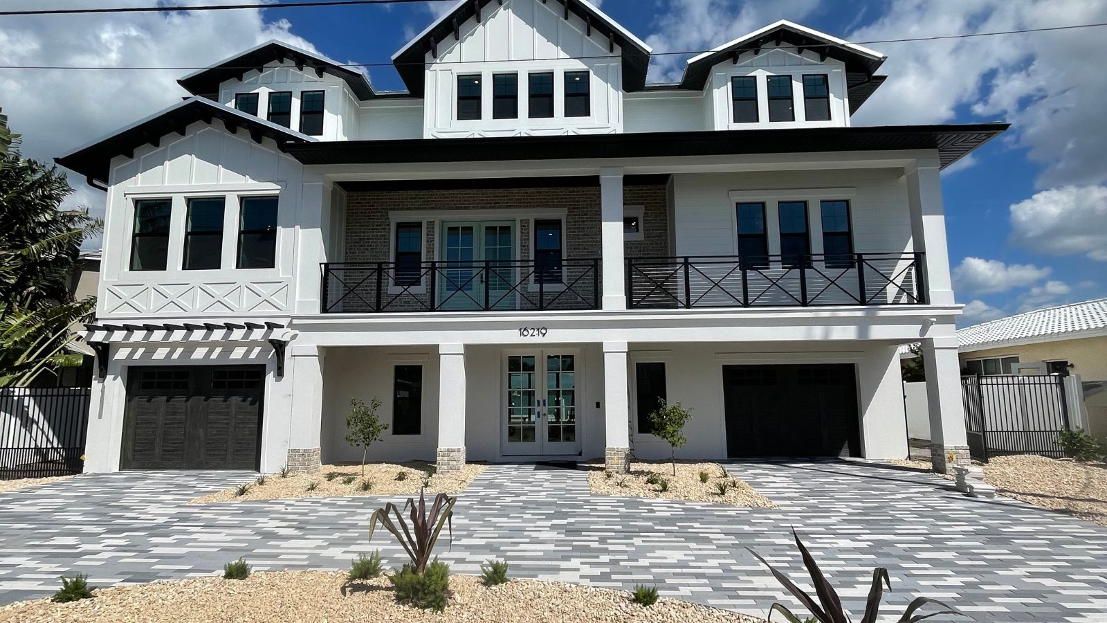 Coastal home exterior with balconies, covered patio, elevated design, and durable materials suited for waterfront living