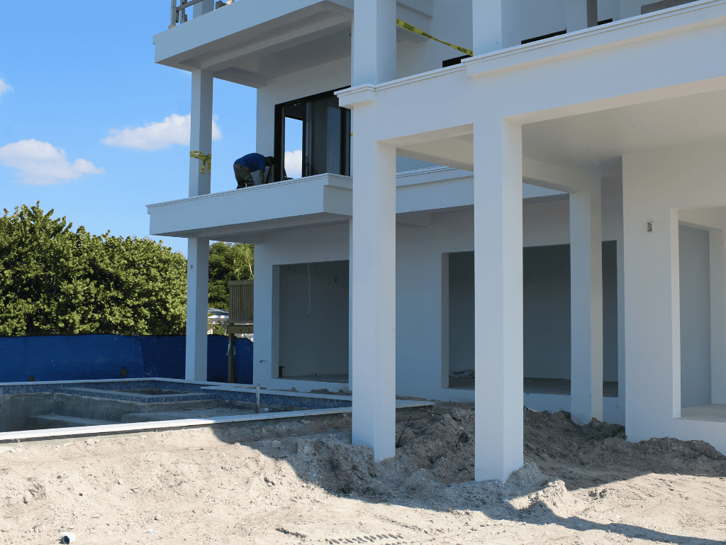 user-inserted Modern coastal concrete shell luxury home under construction with elevated columns and structural framing