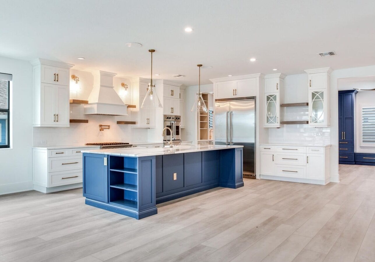 a large kitchen with white cabinets and blue counter tops