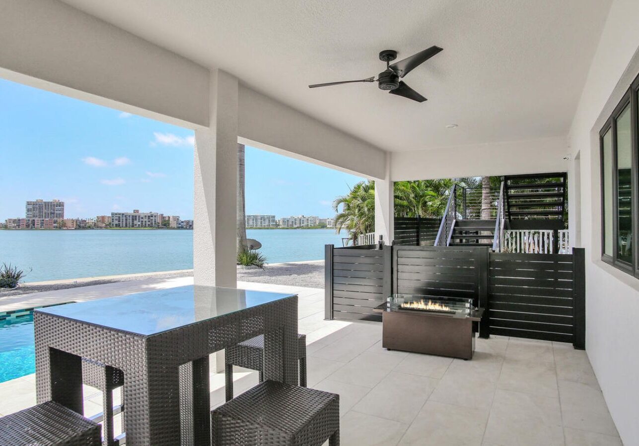 Outdoor patio area with a table set, chairs, and a view of the water